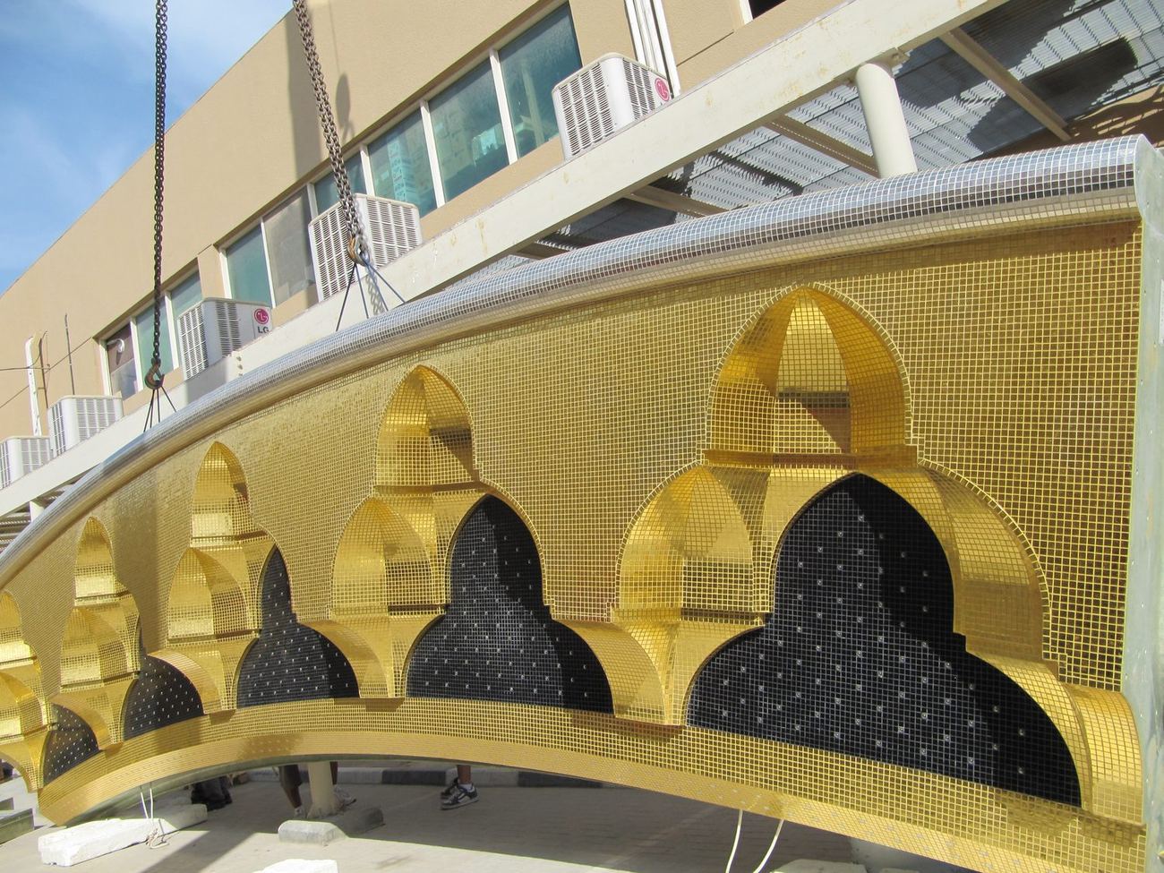 Row of pointed arches clad in gold mosaic with black infill