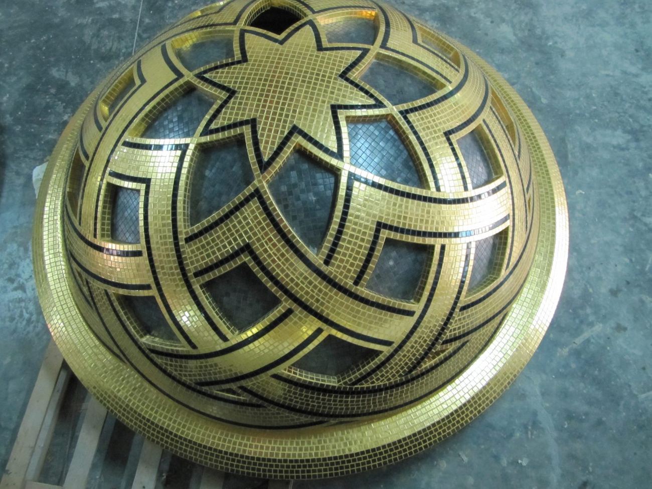 Circular gold mosaic medallion with an interlaced star pattern