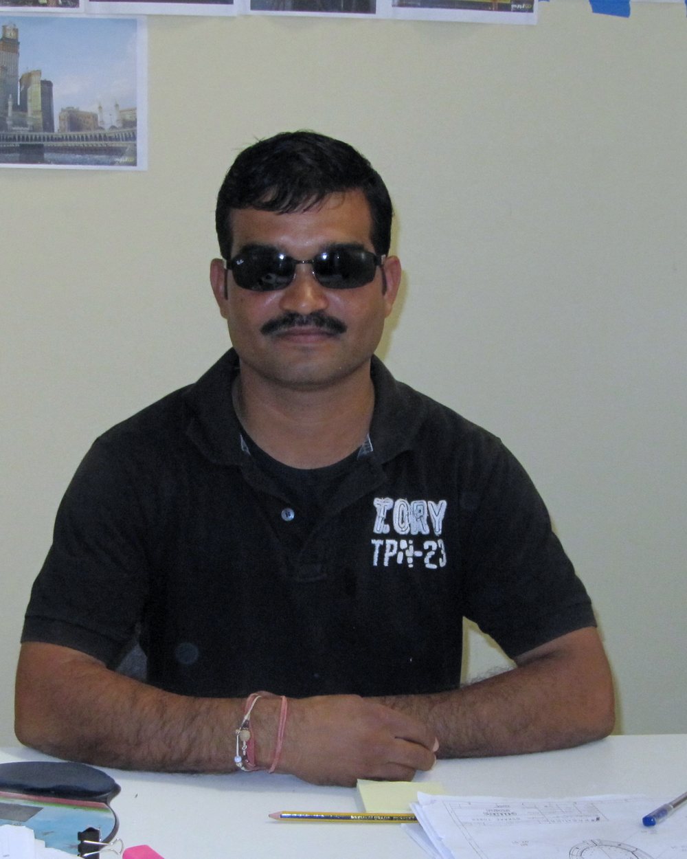 Vinod Yadav at his site office desk, with setting-out drawings and project clippings behind him