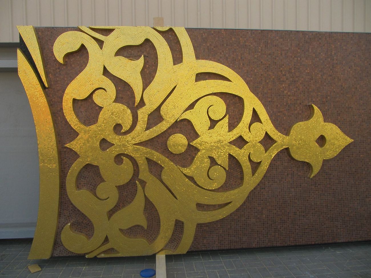 Gold mosaic ornament pieces on a dark red substrate