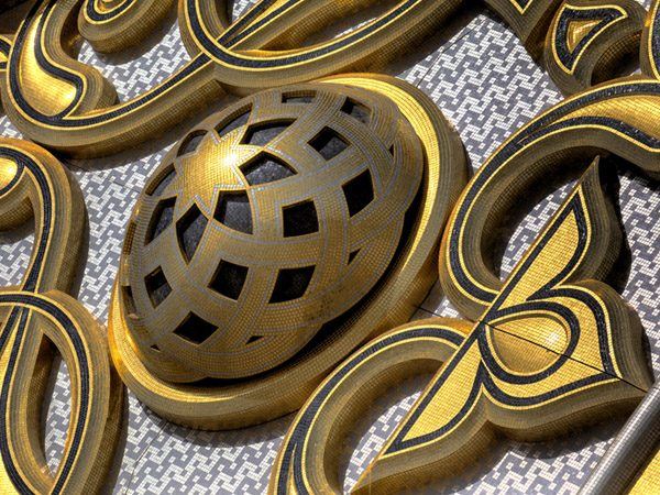 Pierced gold mosaic sphere set within scrolling ornament