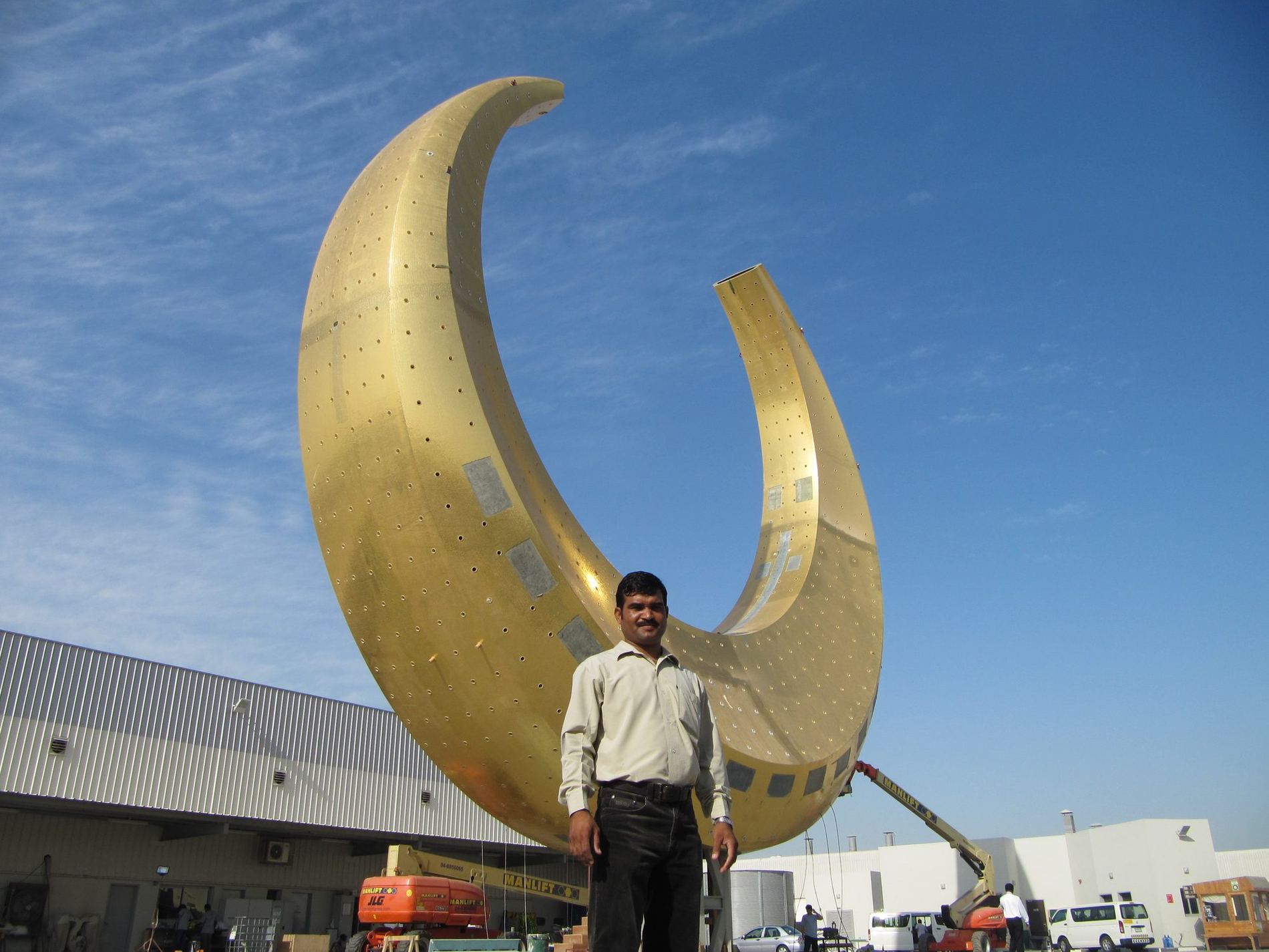 Gold mosaic crescent finial against an open sky