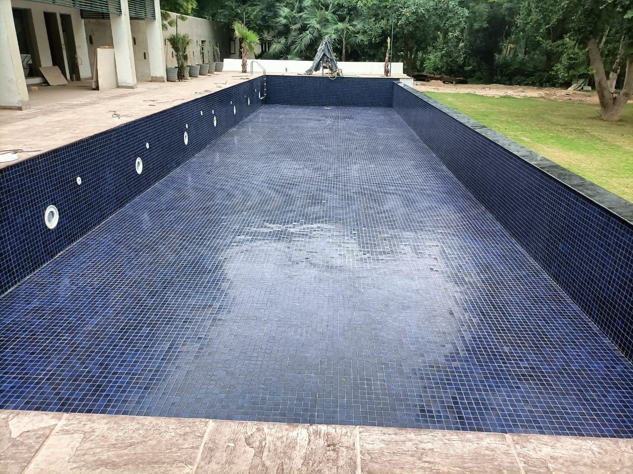 Pool shell part-lined in blue mosaic during construction
