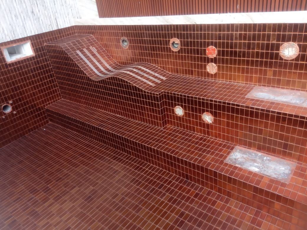 Spa pool lined in terracotta red mosaic with stepped seating