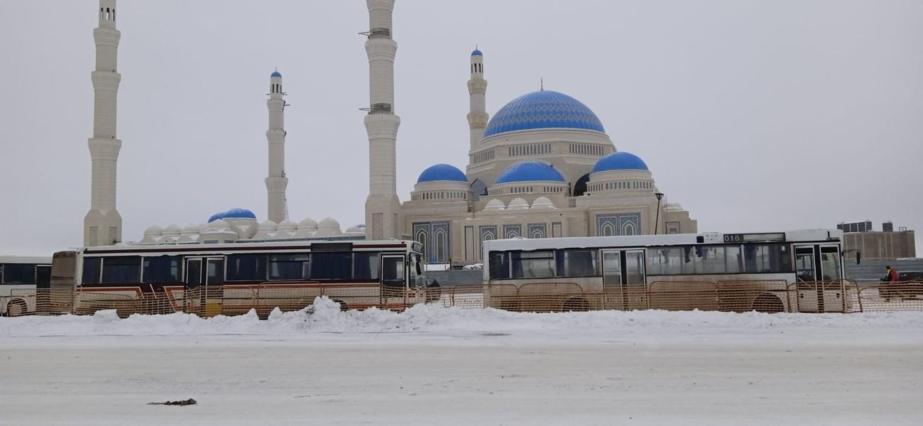 Astana Grand Mosque with blue domes and four minarets, photographed in snow
